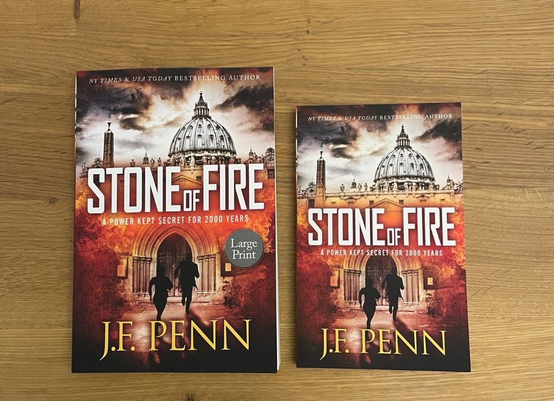 Stone of Fire large print paperback by J.F. Penn next to the standard paperback, showing the bigger page size